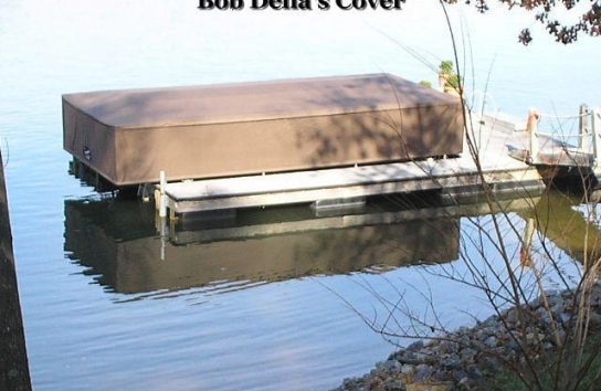 Full sized boat cover for a pontoon boat on a floating dock. Brown color