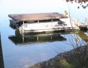 Full sized boat cover for a pontoon boat on a floating dock. Brown color