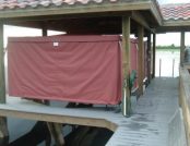 Full sized boat cover for a pontoon boat on a floating dock. Maroon color