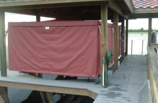 Full sized boat cover for a pontoon boat on a floating dock. Maroon color