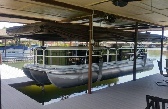 Pontoon boat on a floating dock with the touchless boat cover
