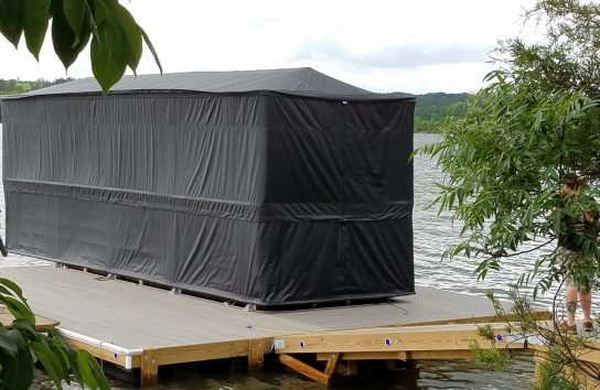 Pontoon boat on a floating dock with the touchless boat cover. Automatic boat cover
